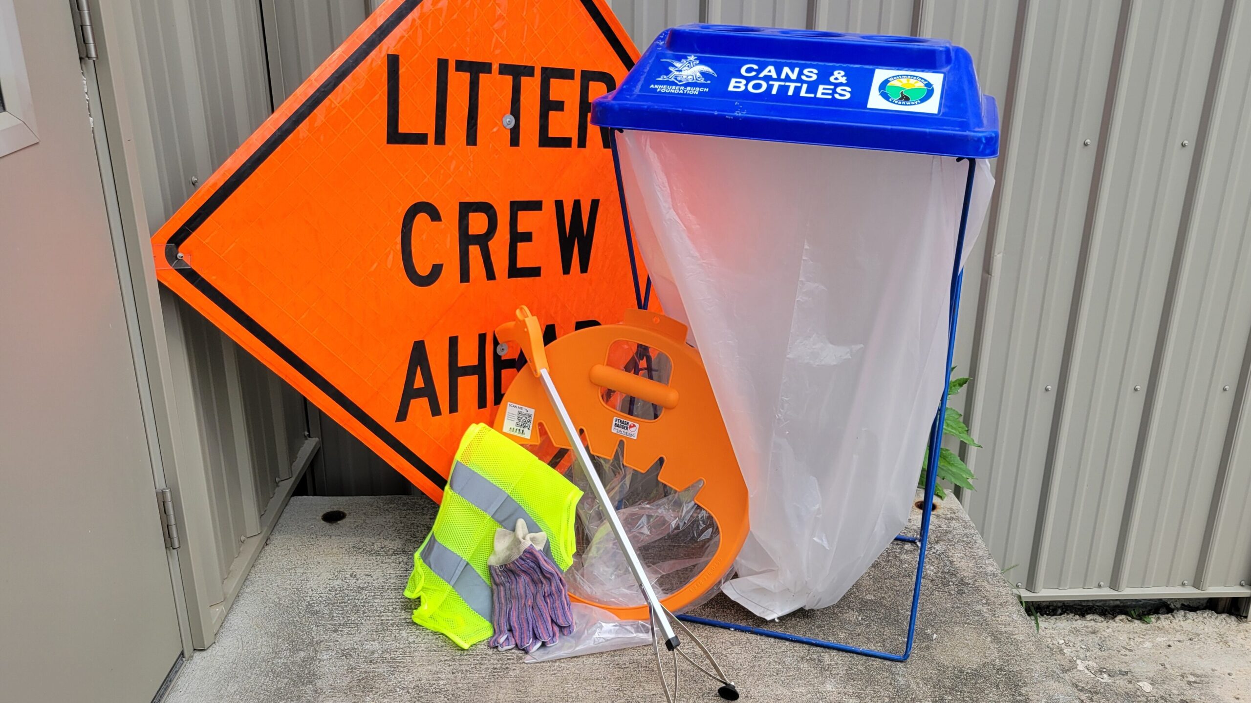 Litter cleanup supplies, including recycling bins, safety vests, gloves, and trash grabbers.