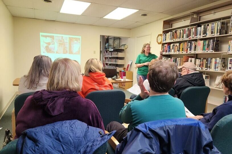 staff member presenting a program to a group of adults